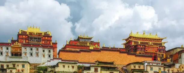 The buildings of Buddhist Ganden Sumtseling Monastery (Songzanlin Monastery) in Shangri-La, Yunnan with the sun shining on the buildings of the manastery