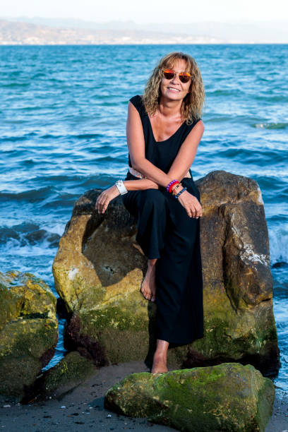 istock woman more than 50 posing dressed in black in beach zone 1423621552