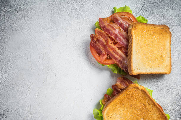 blt поджаренный сэндвич с беконом, помидорами и листьями салата. серый фон. вид сверху. пространство для копирования - sandwich delicatessen bacon lettuce and tomato mayonnaise стоковые фото и изображения