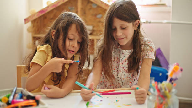 istock Sisters at home drawing and painting together 1423623540