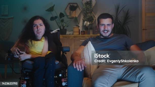 Woman With Disability And Man Watching Tv Stock Photo - Download Image Now - 20-24 Years, 35-39 Years, Adult