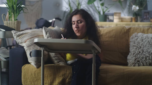 istock Woman with a disability drawing at home 1423623860