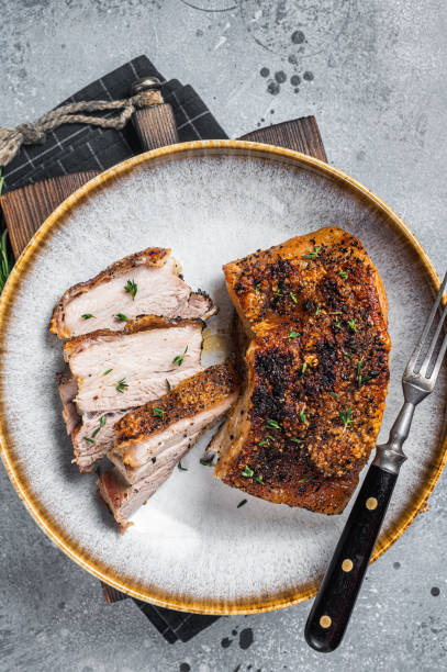 istock Filipino marinated pork belly with crust in a plate. Gray background. Top view 1423624254
