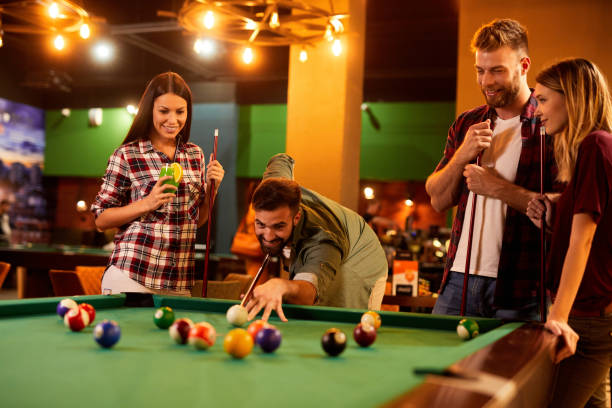 istock Group of friends having fun while playing pool in a local pool hall 1423624537