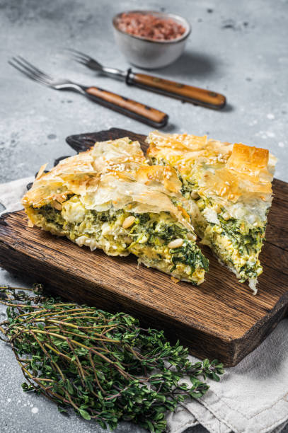 greek pie spanakopita with spinach and cheese on wooden board. gray background. top view - pie spinach spanakopita filo pastry imagens e fotografias de stock