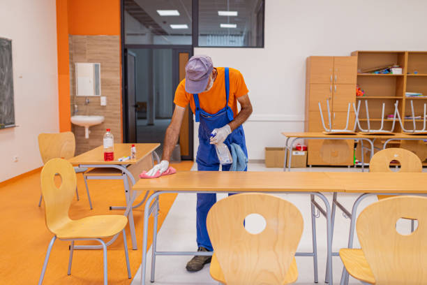 istock A male janitor wiping a surface while spraying it with product 1423626340