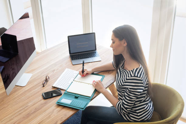 istock Confident businesswoman sitting at desk while working from home 1423627154
