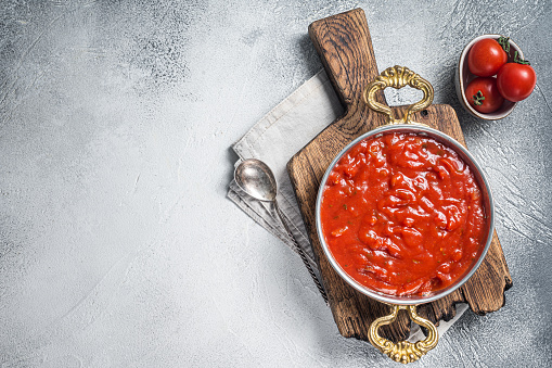 Classic Italian tomato sauce with basil for pasta and pizza in skillet. White background. Top view. Copy space.