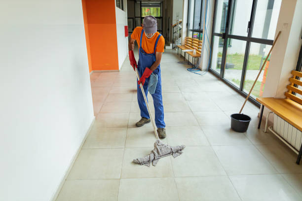 Senior adult janitor cleaning floor at school stock photo