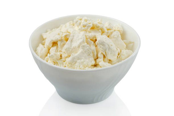 istock Home made cottage cheese in a white bowl on a white background isolated 1423629799
