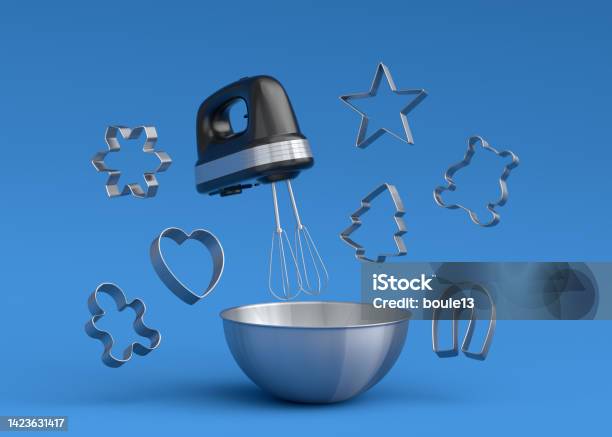 Metal Bowl With Electric Mixer And Cookie Cutters On Blue Background Stock Photo - Download Image Now