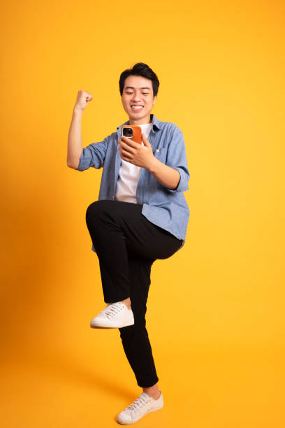 istock full body image of asian man posing on yellow background 1423631497