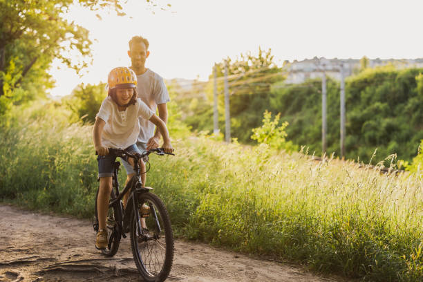 istock Father teaching his son how to ride a bicycle 1423631778