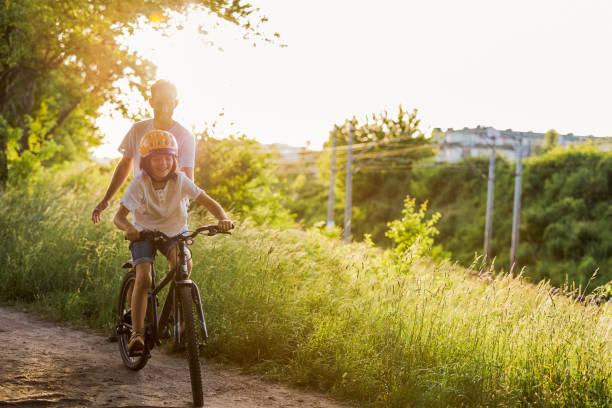 istock Father teaching his son how to ride a bicycle 1423631801