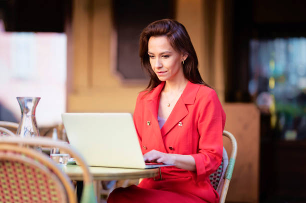 istock Brown haired woman sitting in a cafe and using her laptop 1423632682