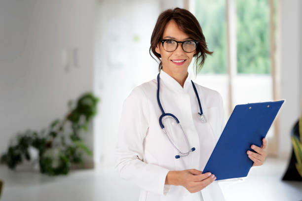 istock Smiling female doctor looking at camera and smiling while standing on the corridor 1423632693