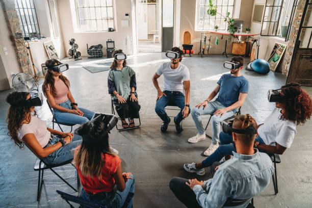 Group of people sitting in circle wearing virtual reality VR glasses during a meditation group therapy session stock photo