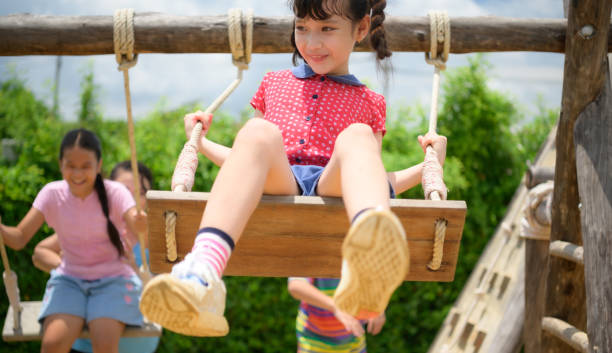 istock Childrens having fun swinging on a swing on a clear day 1423633691