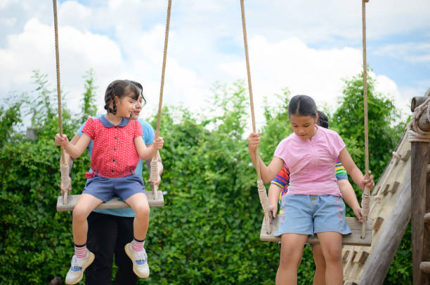 istock Childrens having fun swinging on a swing on a clear day 1423633693