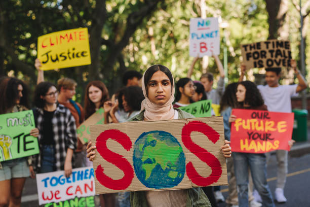 istock Muslim climate change activist holding a poster 1423636102