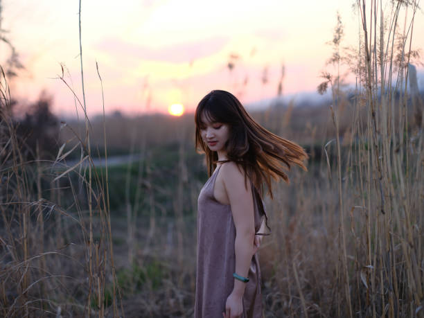Girl in grassland by the lake. It was taken in suburb of Hangzhou, Zhejiang, China. The place name North Lake.
