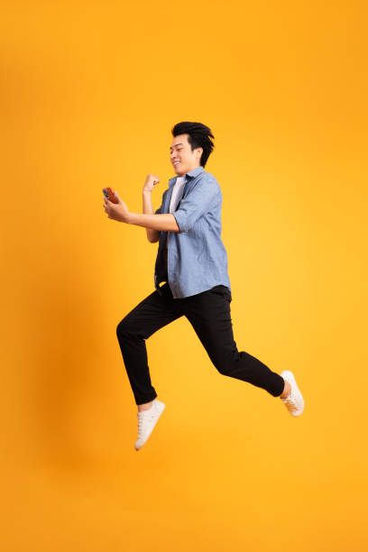 istock full body image of asian man posing on yellow background 1423636735