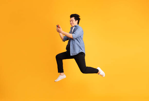 istock full body image of asian man posing on yellow background 1423636740