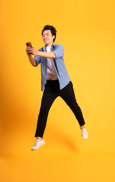 istock full body image of asian man posing on yellow background 1423637192
