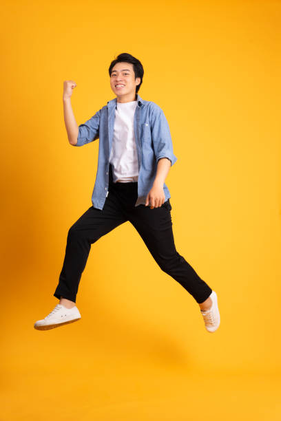 istock full body image of asian man posing on yellow background 1423637508
