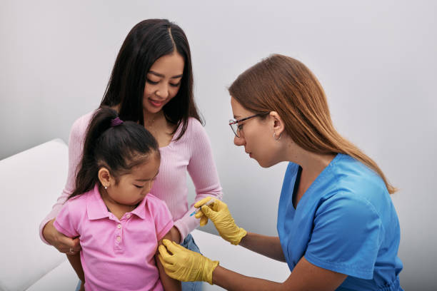 menina coreana e sua mãe durante a vacinação por clínico geral no consultório médico. imunizações infantis e vacinas de rotina - vacina da poliomielite - fotografias e filmes do acervo