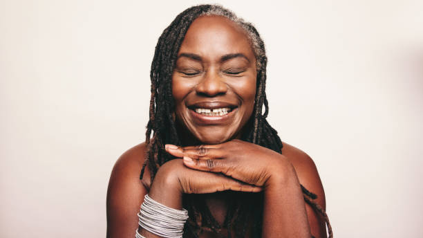 Cheerful woman with dreadlocks smiling with her eyes closed