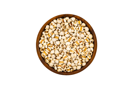 Top view or flat lay of fresh raw millet or sorghum in wooden bowl isolated on white background with clipping path.
