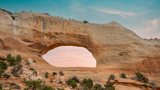 Sunset at a natural arch in Arches National Park, Utah, USA.