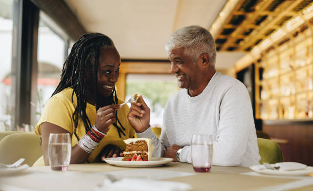 istock Happy senior couple sharing a delicious cake in a cafe 1423641909