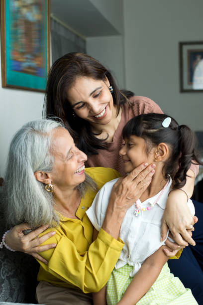 femme heureuse avec grand-mère embrassant sa petite-fille - family retirement smiling multi generation family photos et images de collection