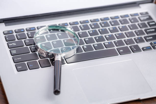 istock Laptop computer keyboard with magnifying glass, concept of search 1423642745