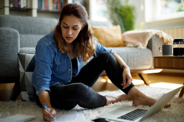 Woman calculating finances at home stock photo