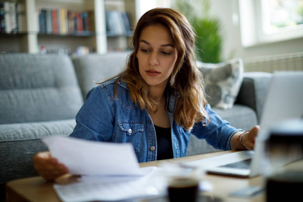 istock Woman calculating finances at home 1423646171