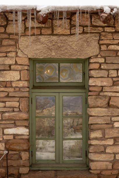 Aged wooden closed shutter, old stone wall rural building background at Gavdos island, summer destination Crete Greece. Worn window plank.
