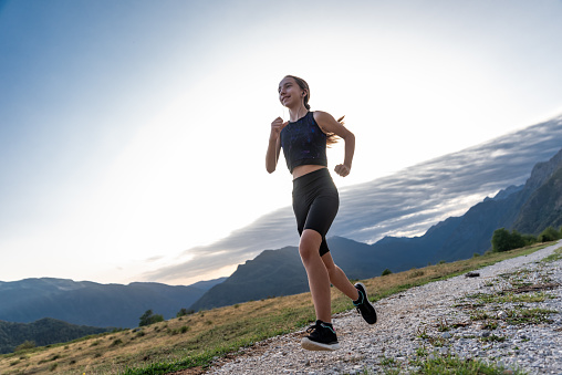 Young Girl at the Sunset Trail Running in the European Alps