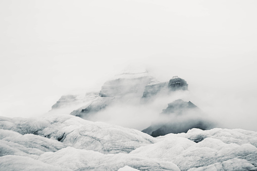 A small mountain under clouds over a glacier in Svalbard