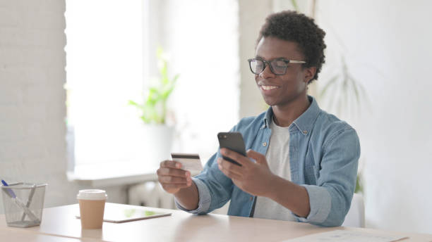 istock Young African Man Shopping Online on Smartphone 1423650400