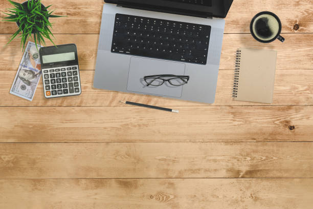 istock Flat lay of top view desk account financial money finance work table with computer notebook and pencil work space on little blur wood background includes copyspace for add text or graphic 1423650718