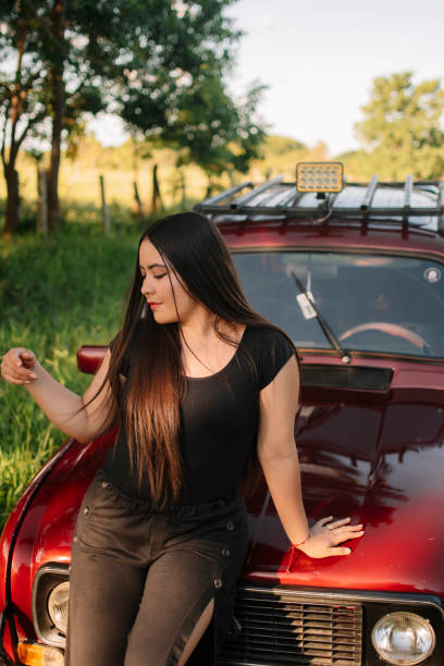 Relaxed girl on a car in the middle of nature and a beautiful landscape
