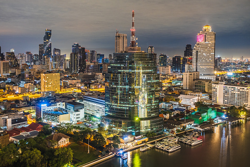 Bangkok City skyline view of Chao Phraya River and modern cityscape downtown district at night, High angle view, Thailand