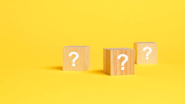 istock front view on wood cubes with white question marks. many question arising concept, yellow background 1423658553