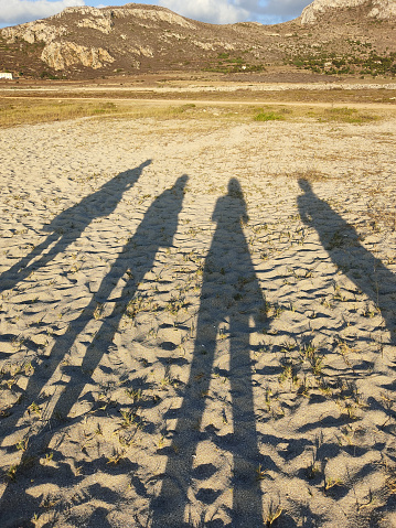 long shadows of 4 friends in the sand of favignana