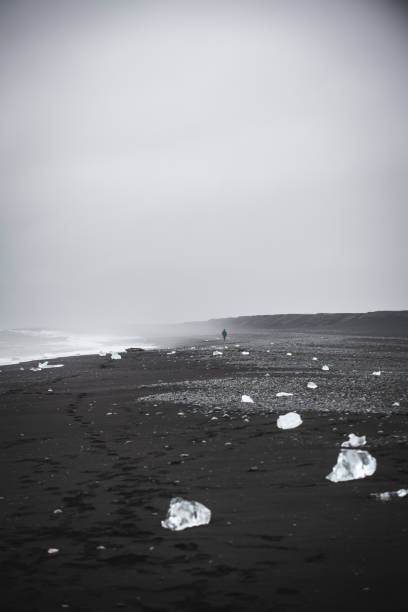 Distant walking on Black Sand Diamond Beach Iceland Eystri-Fellsfjara at Jökulsárlón, Southern Iceland