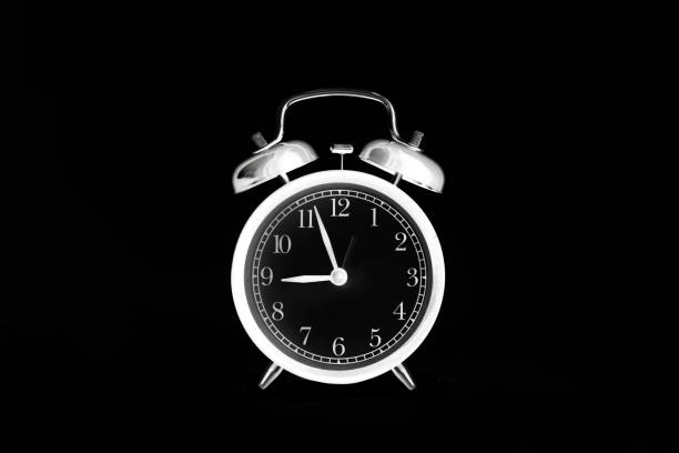 istock White alarm clock isolated on black background. 9 o'clock. Shot in inversion mode 1423660603