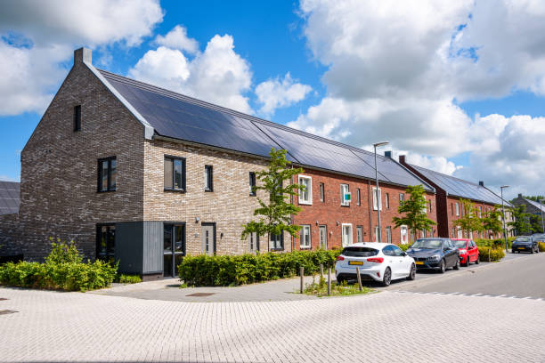Row houses with the rooftop covered with solar panels in a new housing development Row of new energy efficient brick terraced houses with the rooftop covered with solar panels on a sunny summer day. Groningen, Netherlands. row house stock pictures, royalty-free photos & images